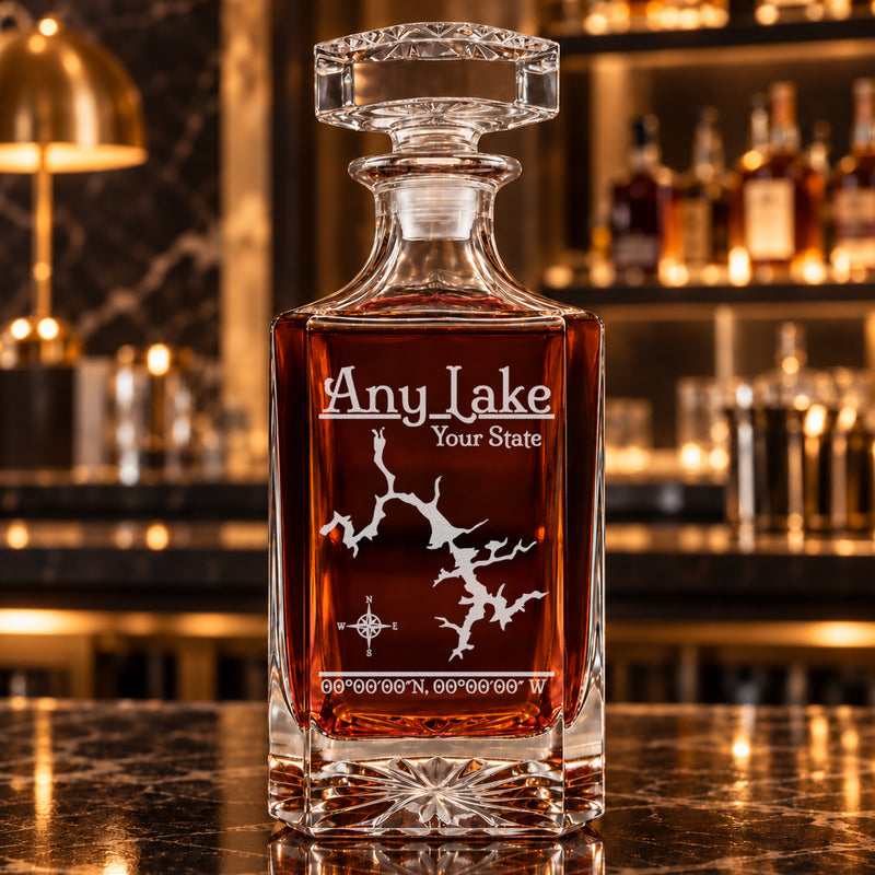 Classic square decanter alone with frosted generic lake artwork, amber whiskey, and a warm bar background.